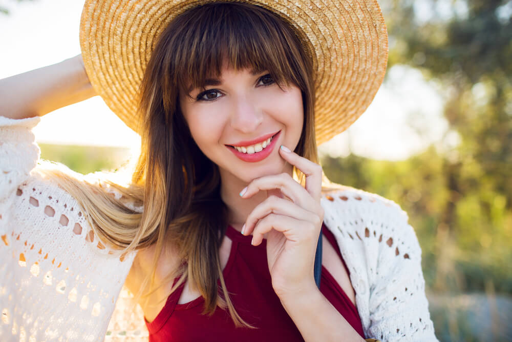 Smiling woman with bangs and a hat